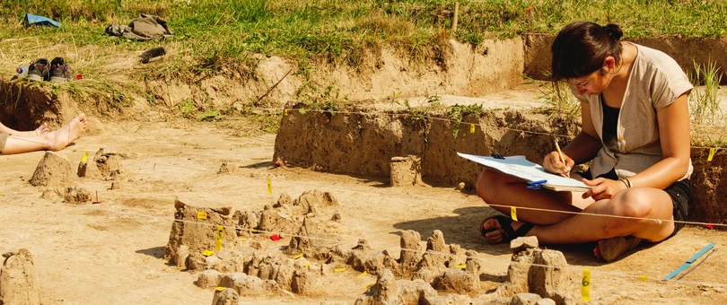 women taking notes at archeology dig