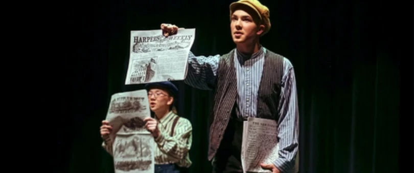 Newsies boy holding newspaper in a play